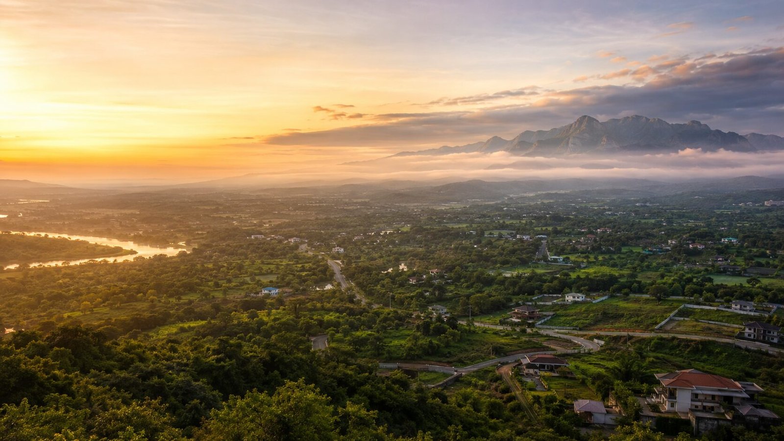 Panoramic sunrise view over the Karjat valley with the Sahyadri mountain ranges, river and scattered homes in Raigad district, Maharashtra
